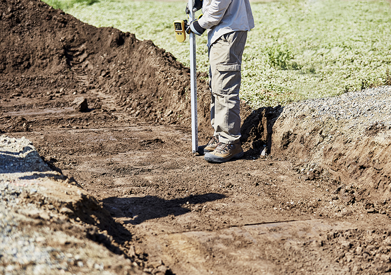 surveyor measuring the dig site of land
