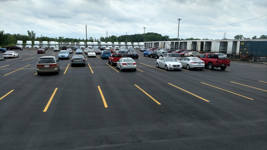 newly paved parking lot from R&R Asphalt with cars parked variously