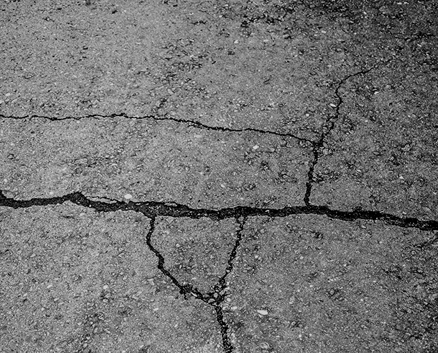 cracked, black and spotted asphalt