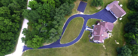 Overhead shot of a newly paved driveway with a grass island in the middle of it